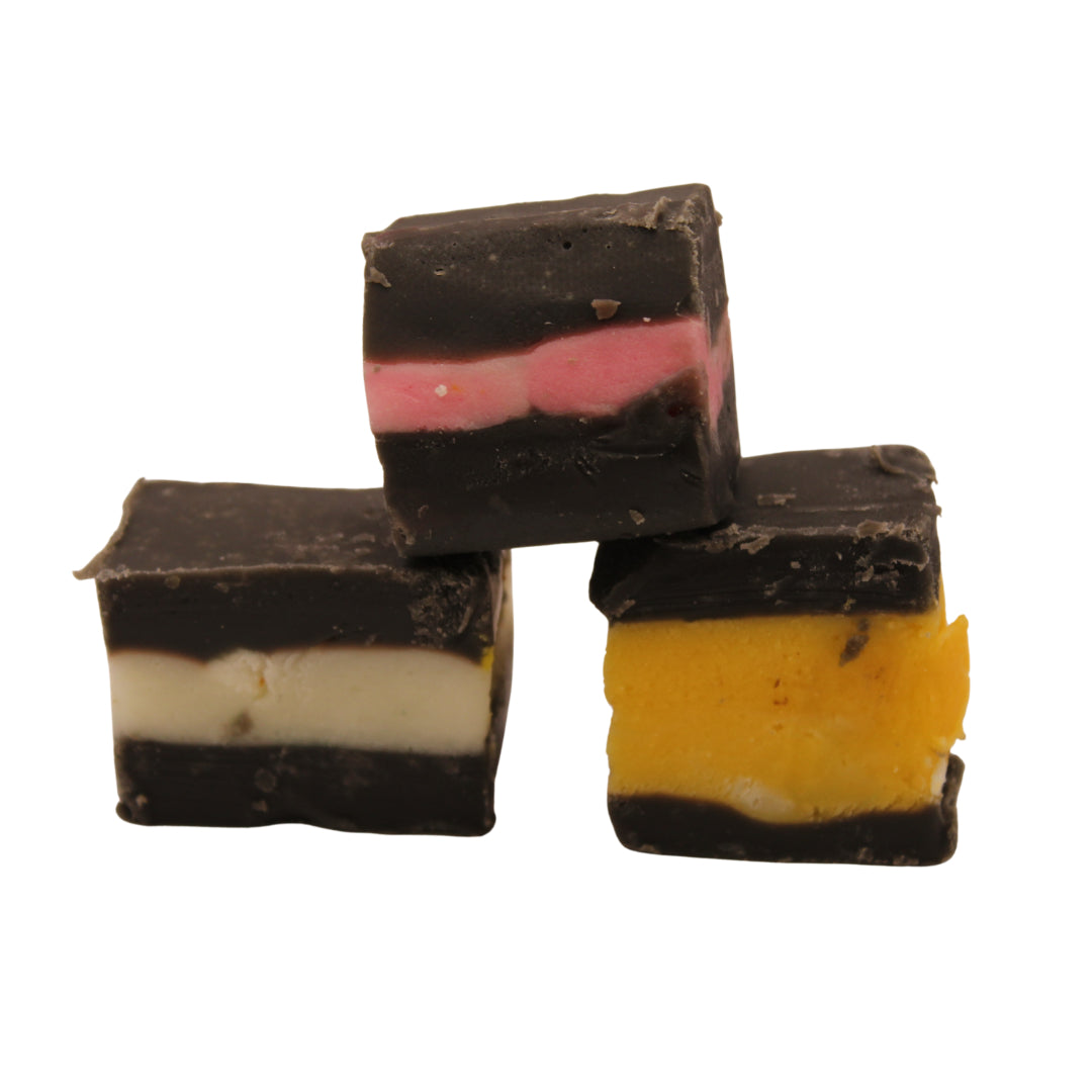 Three pieces of lThe Fudge Factory Liquorice Allsorts on a white background