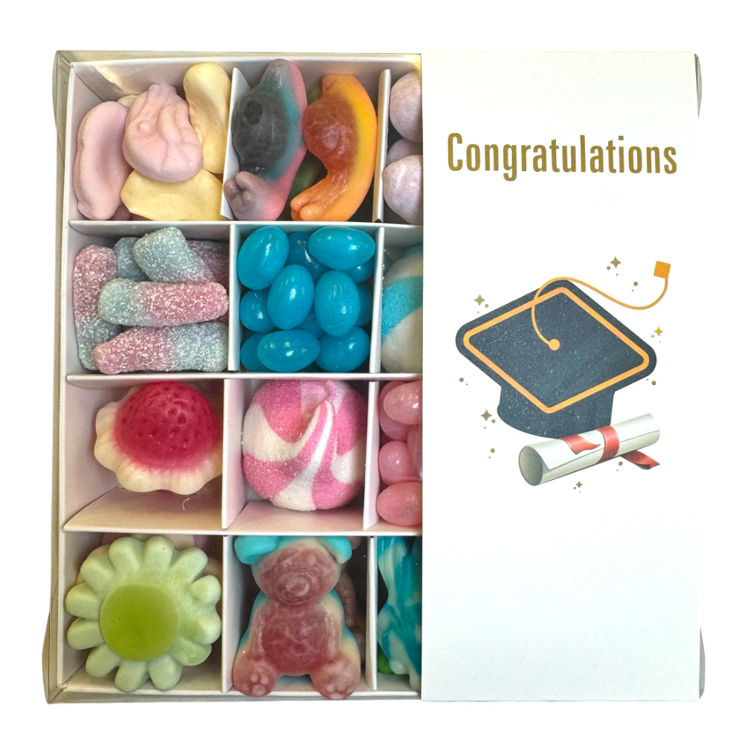 Assorted colorful candies in a box with a 'Congratulations' card featuring a graduation cap and scroll.