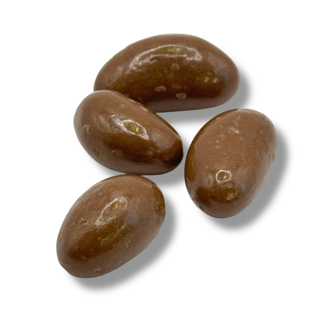 Four chocolate-covered brazil nuts on a white background