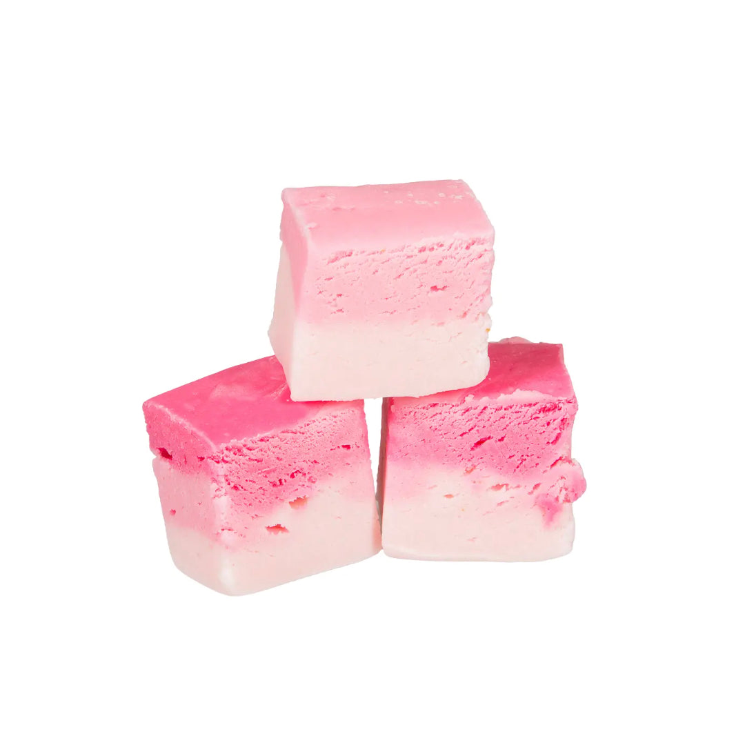 Three chunks of The Fudge Factory Candyfloss Flavoured Nougat on a white background.