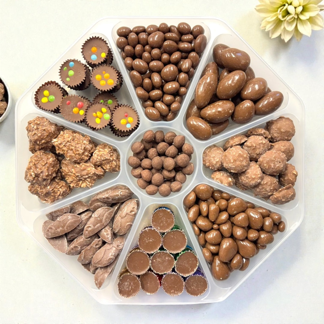 Lollypop Lane platter filled with an assortment of milk chocolate sweets with the lid off on a white background.