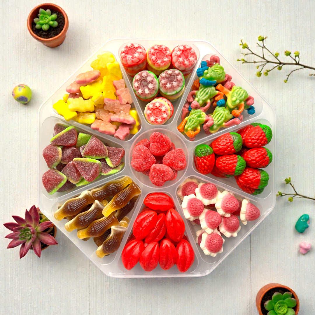 Lollypop Lane sweet platter filled with jelly filled sweets on a white wooden table with various succulents.