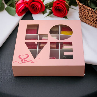 Lollypop Lane Valentine Fudge Gift Box (9 pieces) on a table surrounded by red roses.