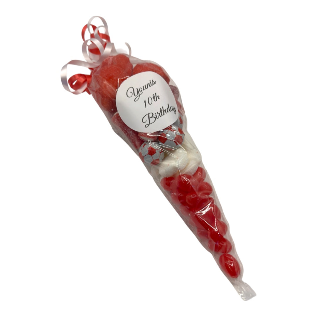 A red heart-shaped candy cone wrapped in clear cellophane with a white ribbon and a round white label that reads 'Yannis 10th Birthday'.