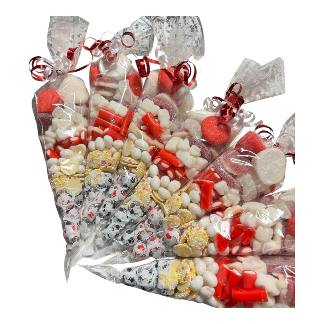 A bundle of individually wrapped sweet cones tied with red ribbons, filled with assorted candies, marshmallows, and chocolate pieces, photographed on a plain white background.