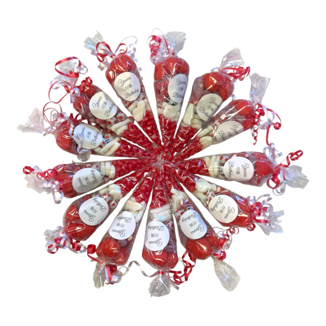A circular arrangement of individually wrapped red party sweet cones with red ribbons and white labels, photographed on a plain white background.