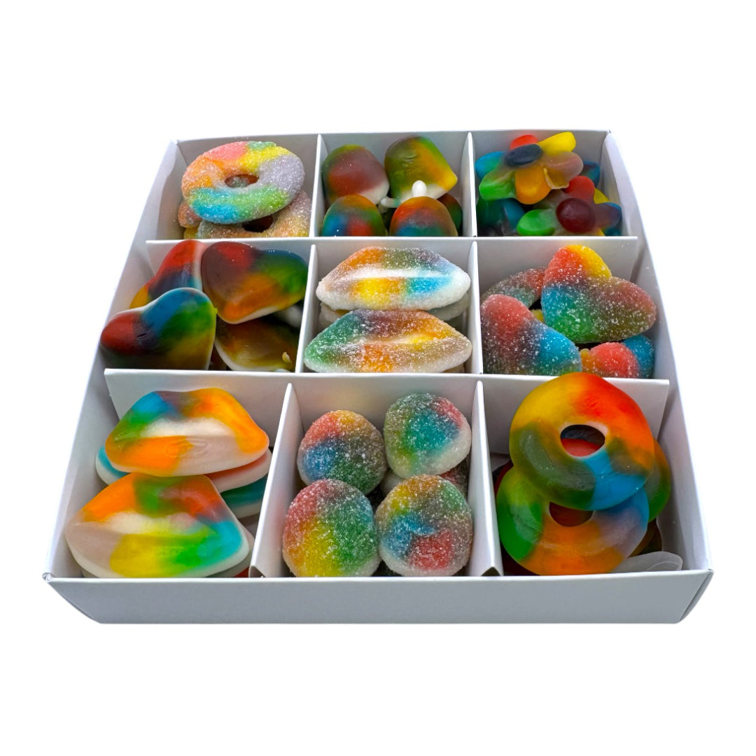 Assorted colorful gummy candies in a white divided container on a white background