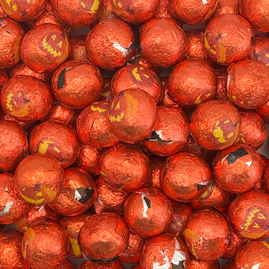 Milk Chocolate Pumpkins with Halloween face designs on a red background