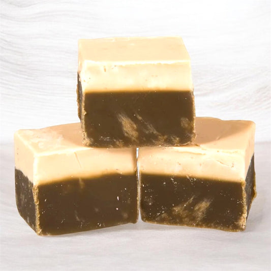 Three chunks of The Fudge Factory Cappuccino Flavoured Fudge on a creamy background.