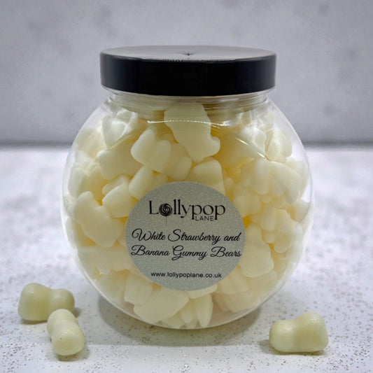 Lollypop Lane Mini Sweet Jar filled with White Strawberry and Banana Gummy Bears. The background features a marble surface.