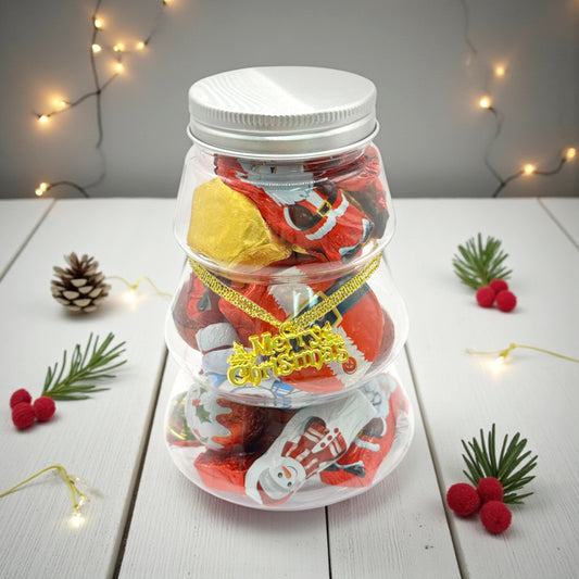 Lollypop Lane Christmas Tree Jar Filled with Seasonal Chocolate. The background features a rustic table with Christmas decor.