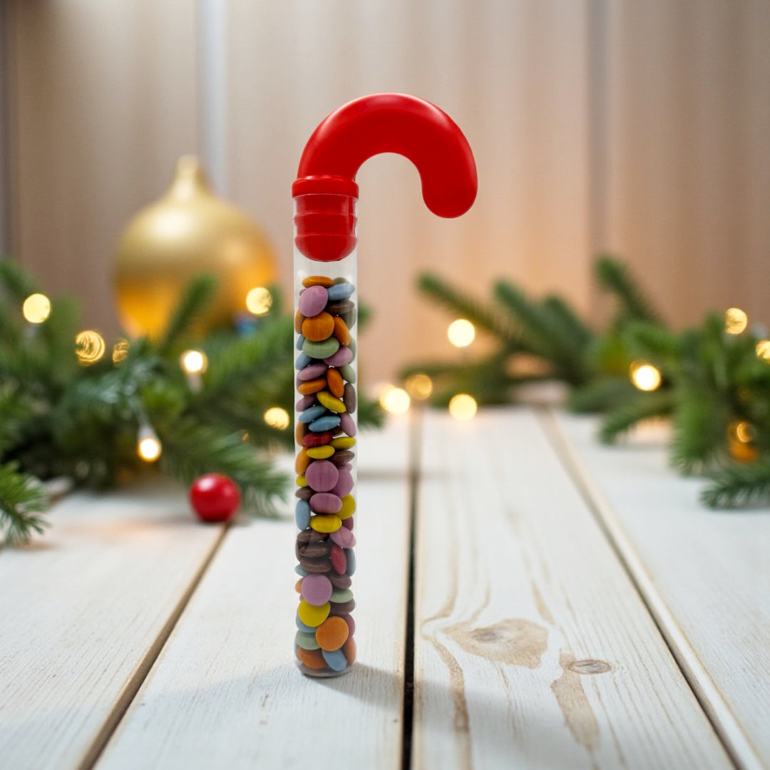 Lollypop Lane Candy Cane filled with Milk Chocolate Beans. The background features a wooded table and Christmas decorations