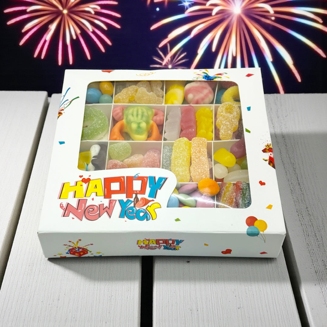 Lollypop Lane Happy New Year Gift Box, Pick n Mix Sweets. The background features a table and fireworks.