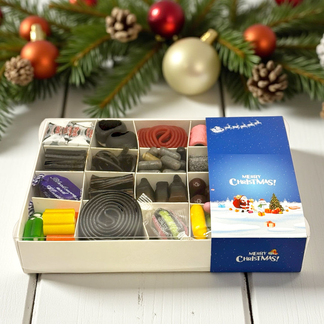 Lollypop Lane Merry Christmas Liquorice Gift Box on a table surrounded by Christmas decorations