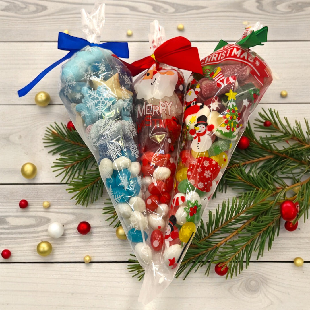 Three Lollypop Lane Christmas-themed sweet cones with decorative ribbons on a wooden surface with festive decorations.
